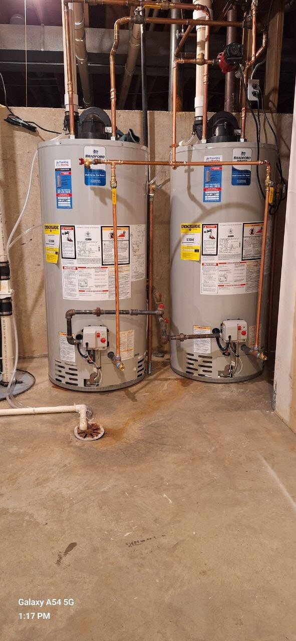 Two tankless water heaters installed with clean copper piping in a residential utility room