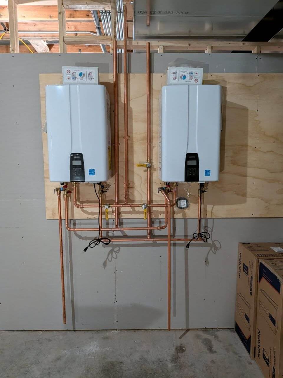 Gas piping manifold with copper and black iron pipe installed along a residential wall